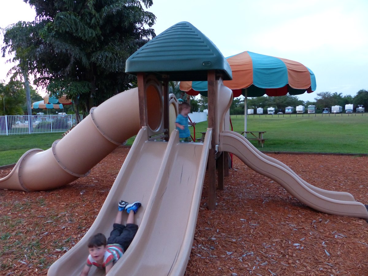 Both boys at the campground playground — Noah sliding down, Vitus at the top