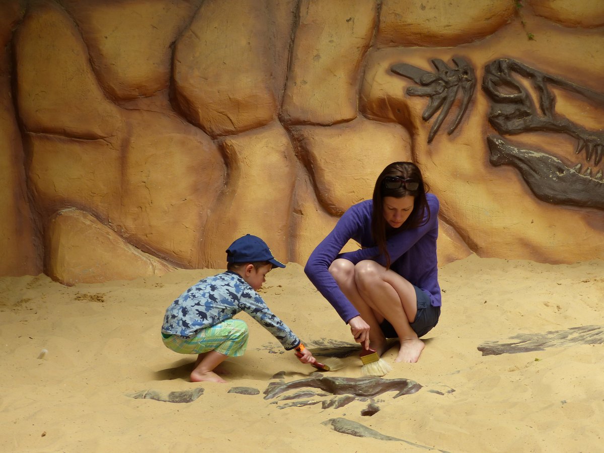 Line and Noah brushing sand off the fossils at the Dinosaur World fossil dig